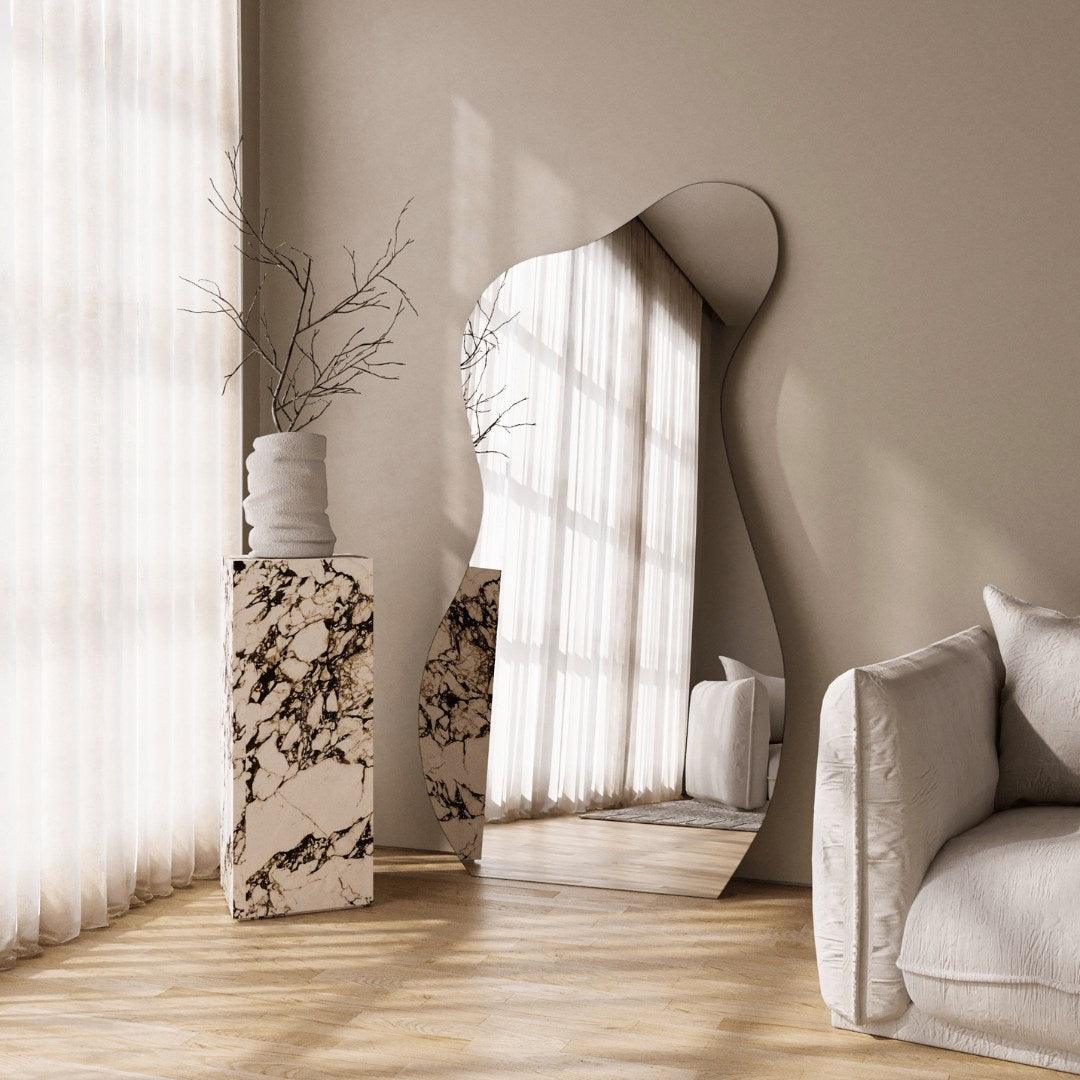 Curvy irregular full-length mirror in a modern interior setting, reflecting natural light. Artistic mirror design, perfect for stylish UAE homes.