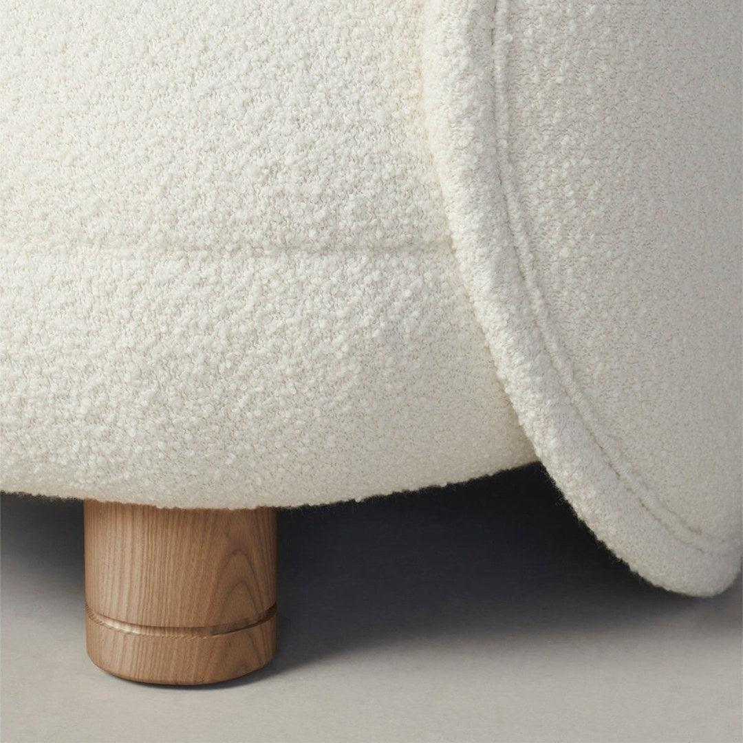 Close-up of the Dima Boucle Armchair featuring soft boucle fabric and sturdy wooden legs, showcasing its craftsmanship and modern design.