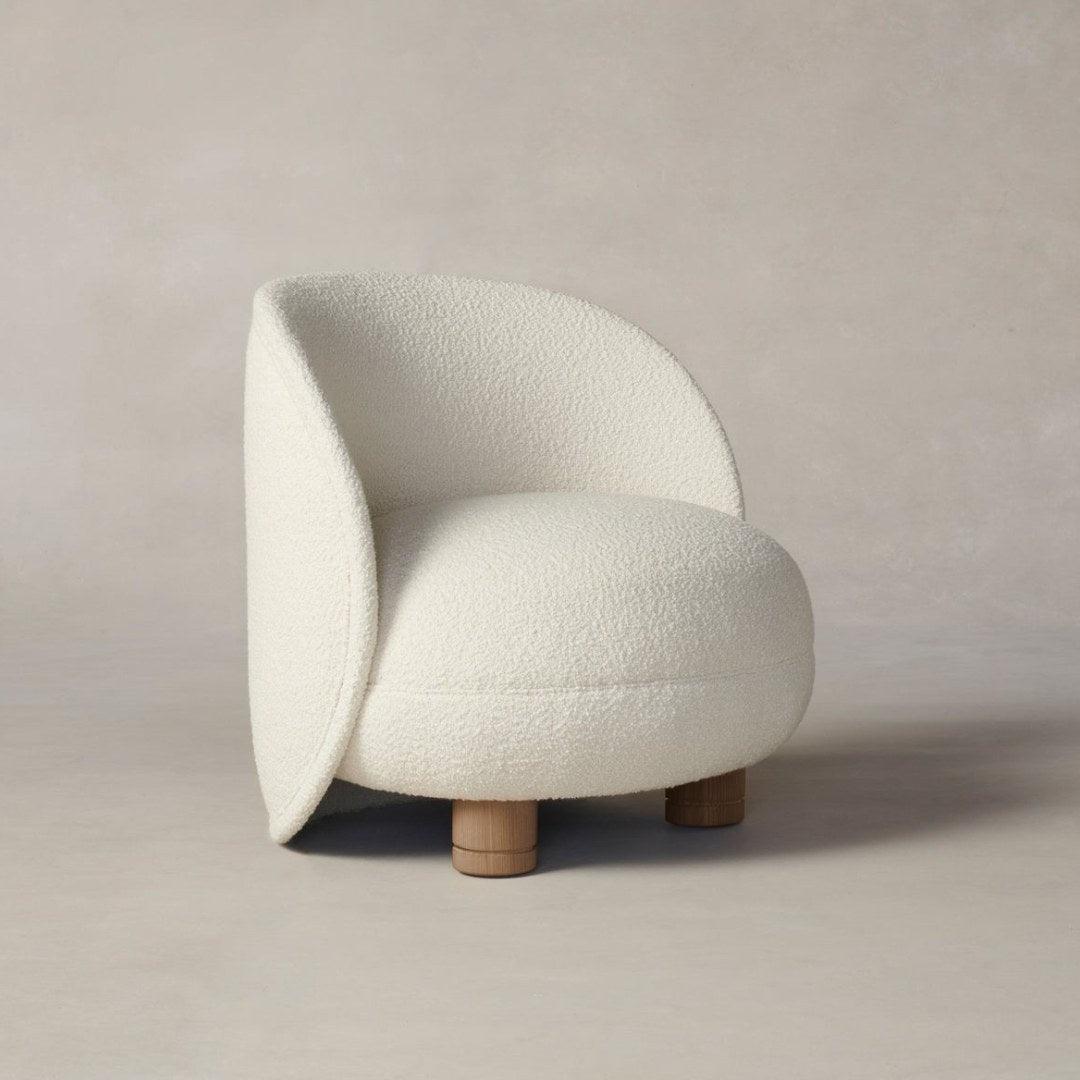 Side view of the Dima Boucle Armchair with soft boucle fabric and wooden legs, showcasing its modern and cozy design for stylish living spaces.