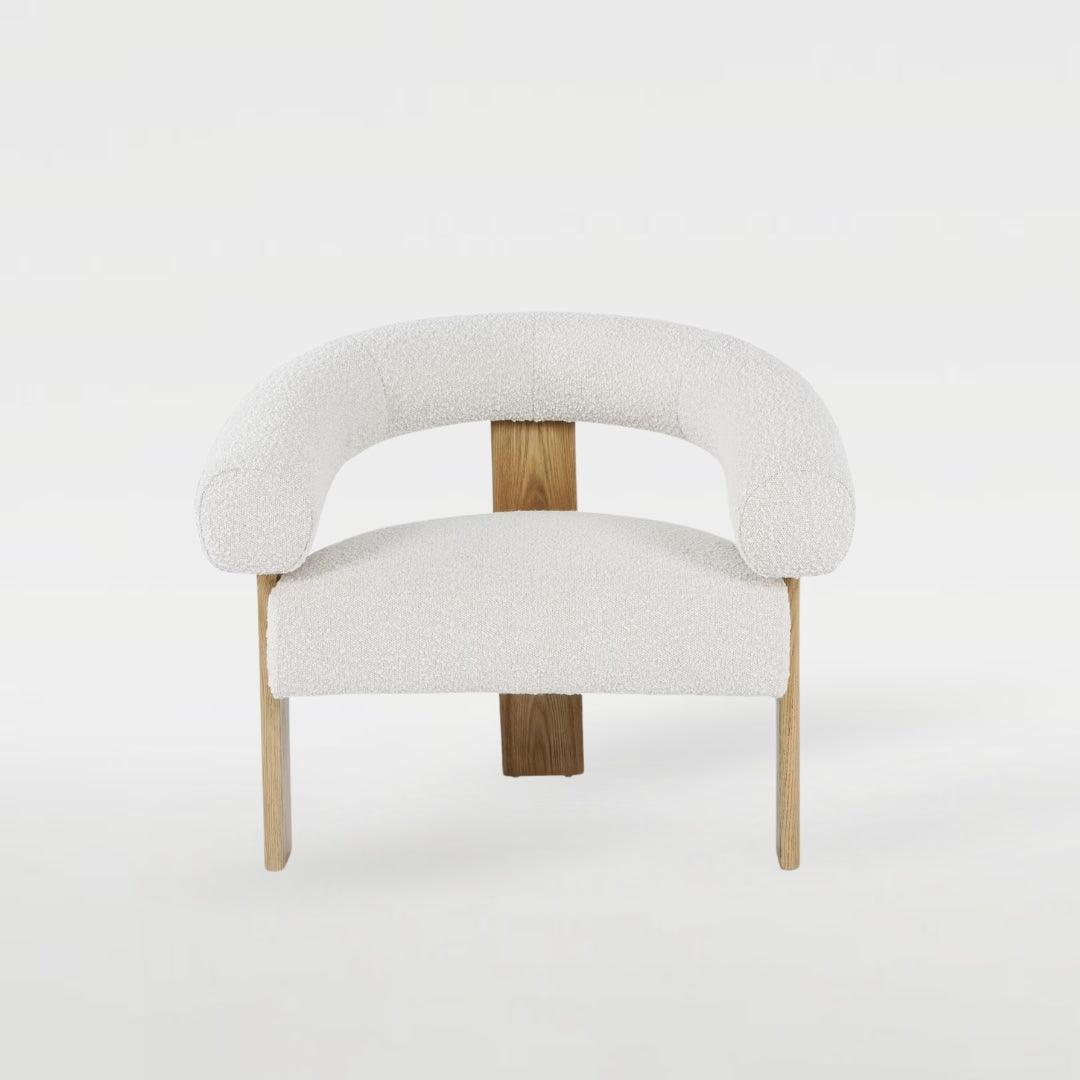 Polly Wooden Leg Armchair with boucle fabric and unique wooden leg design, styled in a modern interior, perfect for elegant and cozy living spaces.