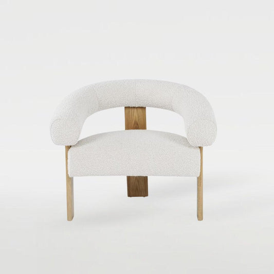 Polly Wooden Leg Armchair with boucle fabric and unique wooden leg design, styled in a modern interior, perfect for elegant and cozy living spaces.