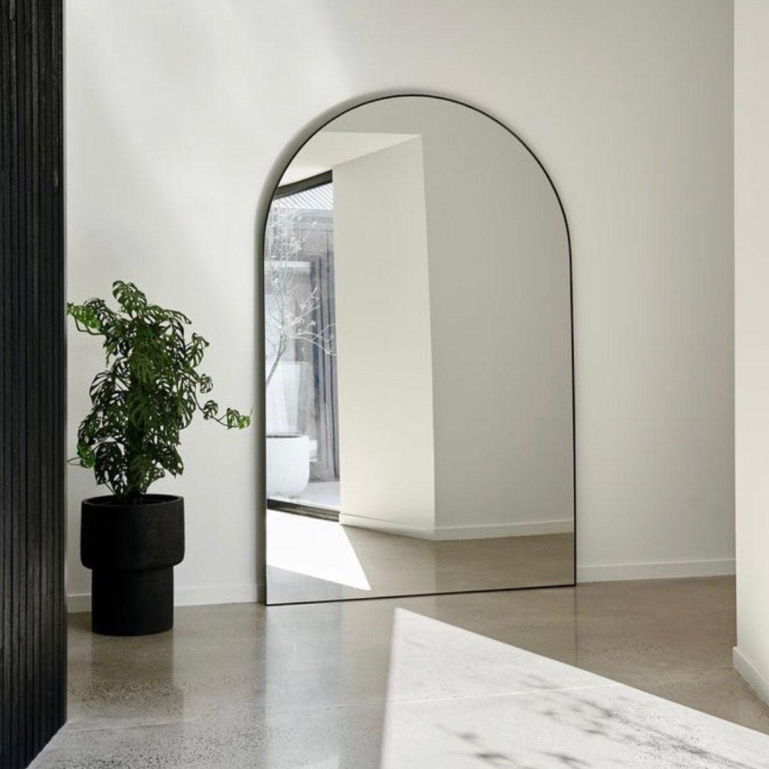 Elegant Kylie arch mirror with sleek black aluminum frame in a modern interior, perfect for enhancing home décor in Dubai, Sharjah, Ajman, and beyond.