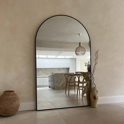 Modern Kylie arch mirror with black aluminum frame reflecting a stylish dining area, ideal for enhancing large spaces and adding elegance to UAE interiors.
