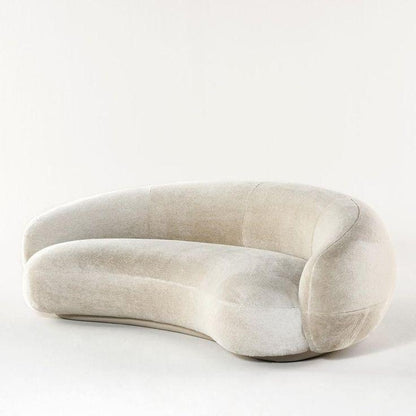 Nara Lounge Sofa with a curved design, upholstered in soft velvet fabric, perfect for modern living rooms and elegant homes in UAE.