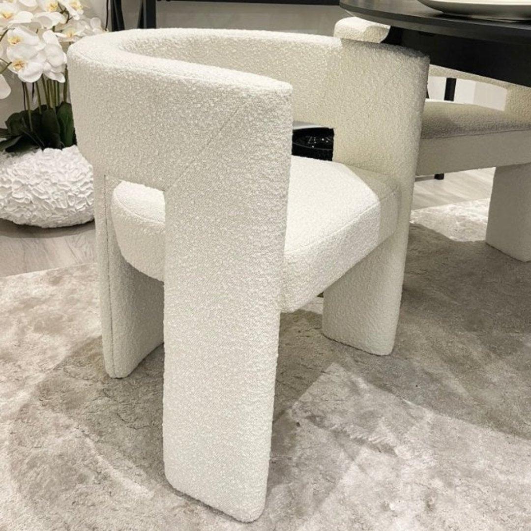 Sia Boucle Chair with boucle fabric upholstery and modern curved design, styled in a dining room setting, perfect for elegant and contemporary interiors.