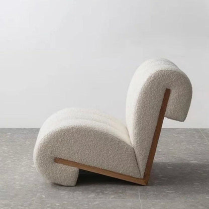 Side view of the Curvy Cloud Accent Chair with boucle fabric and a wooden back, showcasing its bold and modern design, perfect for luxury interiors.