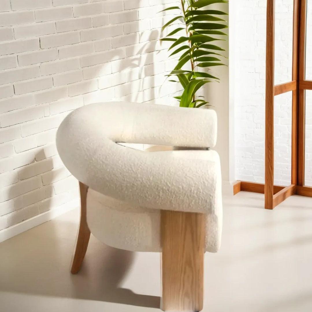 Polly Wooden Leg Armchair in boucle fabric with unique wooden legs, styled in a bright, modern interior, perfect for contemporary living spaces in dubai