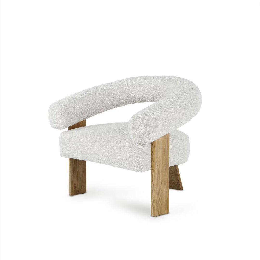 Polly Wooden Leg Armchair in boucle fabric with unique wooden legs, styled in a bright, modern interior, perfect for contemporary living spaces.